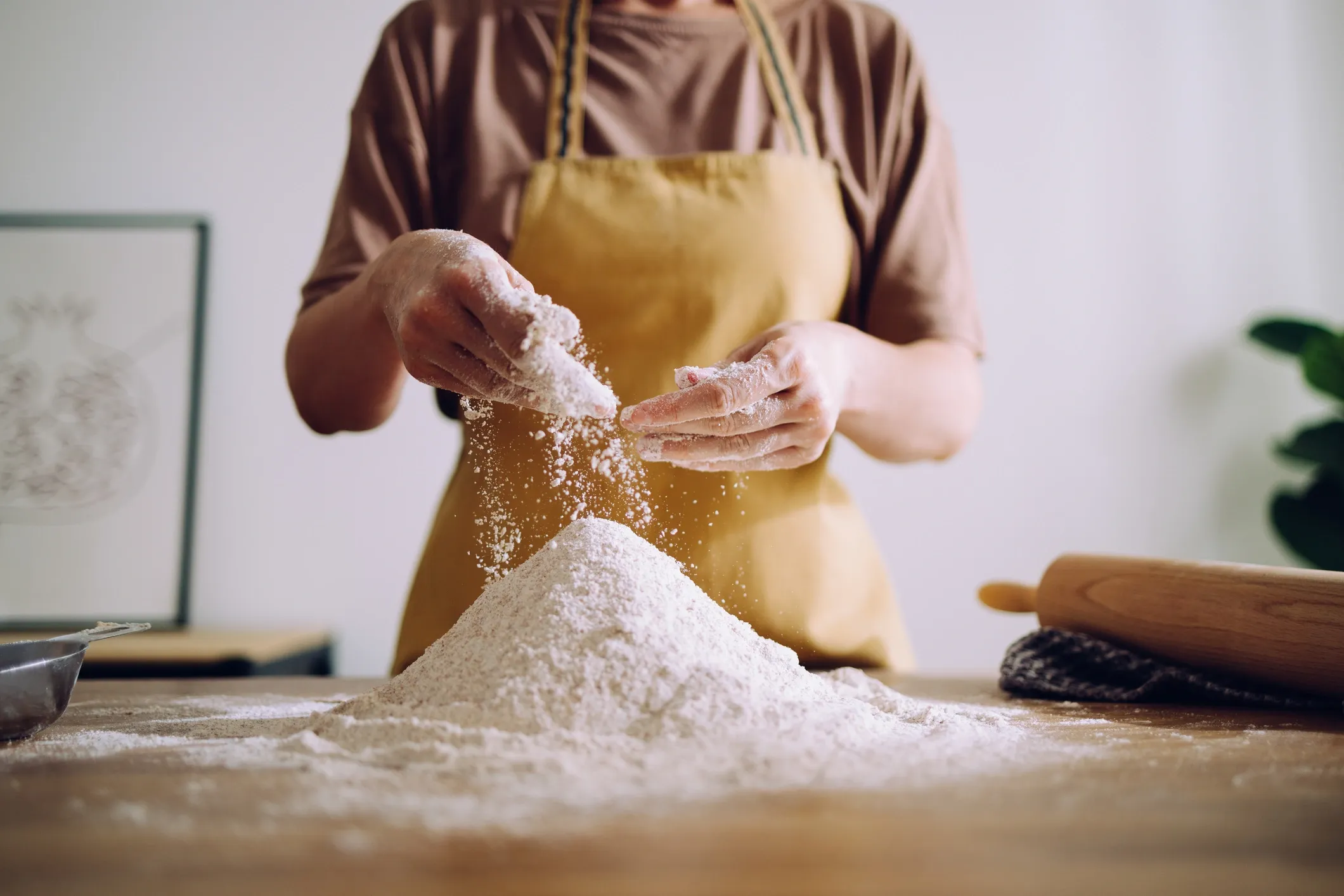 Persona preparando masa fresca sobre una mesa de cocina
